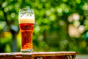 户外木桌上的一杯鲜啤酒