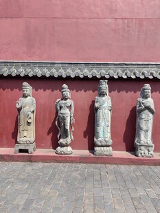 红墙下的精美古代石雕像
