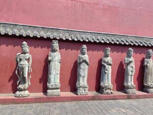 红墙下的古代人物雕像