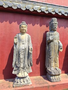 古佛像立于红墙前