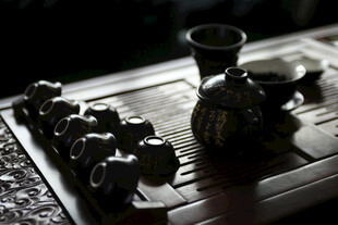 中式茶具摆设于古朴茶盘