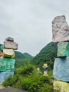 多彩石堆立于青山绿野间