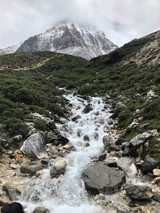 山间溪流绕石伴雪山
