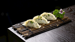 美味蒸饺摆于竹制托盘上