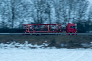 雪地中行驶的红色重型卡车