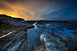 夕阳下的岩石与静谧水洼