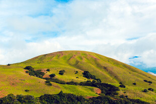 翠绿山丘与蓝天白云美景