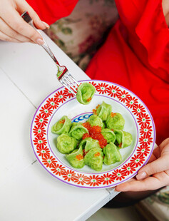 手持餐具享用绿色蔬菜饺子