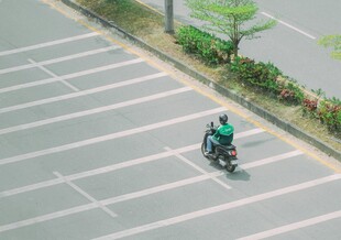 骑电动车穿行空旷停车区