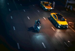 雨夜街头的摩托与出租车