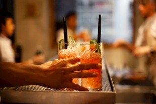 酒吧中手捧色彩绚丽鸡尾酒