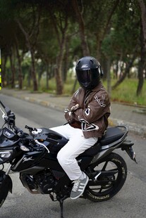 女子帅气跨坐黑色摩托车