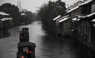江南水乡雪后乌篷船景象