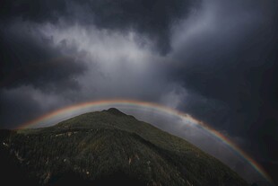 山间彩虹横跨乌云密布处