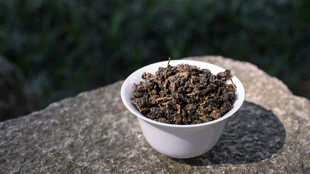 石上白杯盛着干茶叶