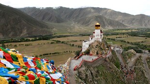 藏区山间经幡与白塔景观