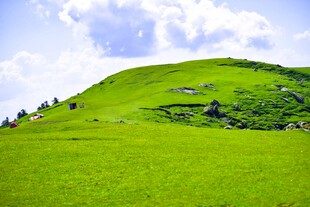 翠绿山丘蓝天白云下美景