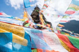 五彩经幡飘扬于蓝天白云下