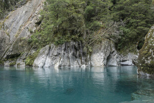 清澈蓝湖旁的葱郁岩壁