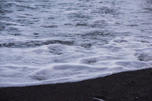 海浪拍打黑色沙滩