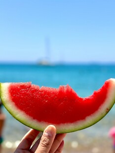 海边手持西瓜的惬意瞬间