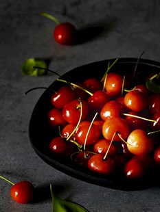 黑盘盛放饱满鲜红樱桃