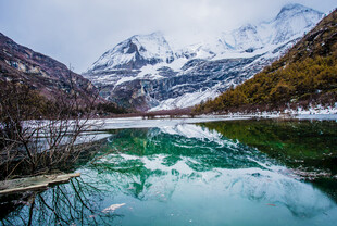 雪山下的静谧碧绿湖泊