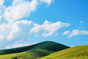 蓝天白云下的翠绿山丘