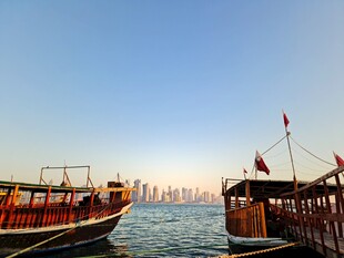 海上古船与远处城市景观