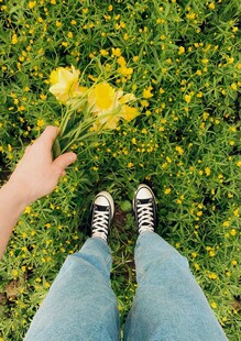 手持黄花站于绿草地