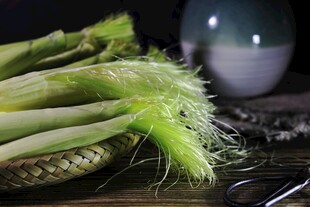 新鲜玉米摆放在深色桌面上