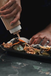 厨师挤酱料于海鲜拼盘上