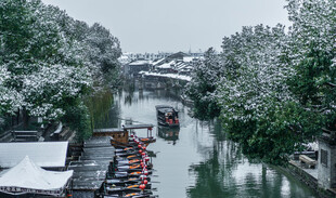 江南水乡雪景中的乌篷船