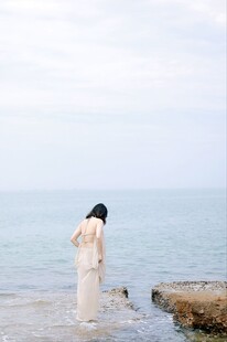 海边白衣女子的静谧时刻
