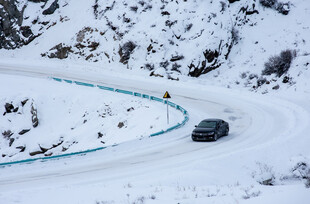 雪地蜿蜒公路上的行驶车辆