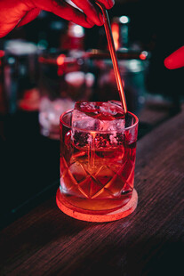 红色鸡尾酒倒入带冰玻璃中