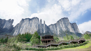 山间木屋旁的壮丽巍峨山峰