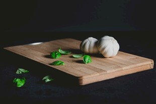 砧板上的大蒜与绿色香草