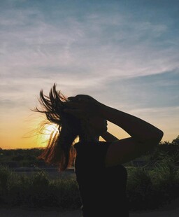 夕阳下舞动发丝的女子