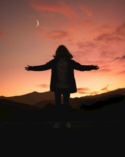 夕阳下张开双臂的孤独身影