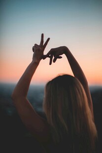 夕阳下女子比手势剪影