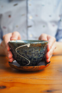 双手捧持古朴茶杯