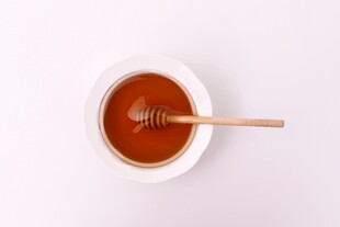 白色碗中蜂蜜与木勺