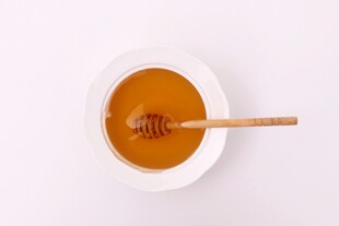 白色碗中蜂蜜与木勺