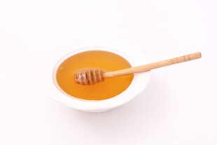 碗中蜂蜜与木质搅拌棒
