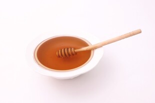 碗中蜂蜜与木质搅拌棒