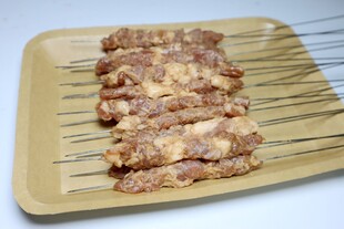 美味烤肉串摆放在木盘上