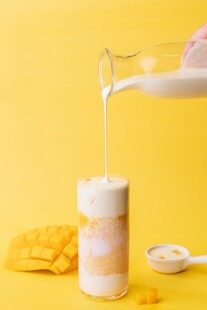 牛奶倒入芒果味酸奶中