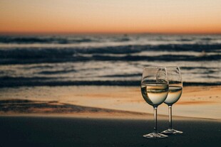 海边夕阳下的两杯白葡萄酒