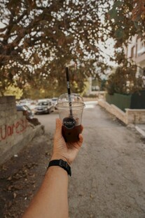 手持咖啡漫步林荫小道